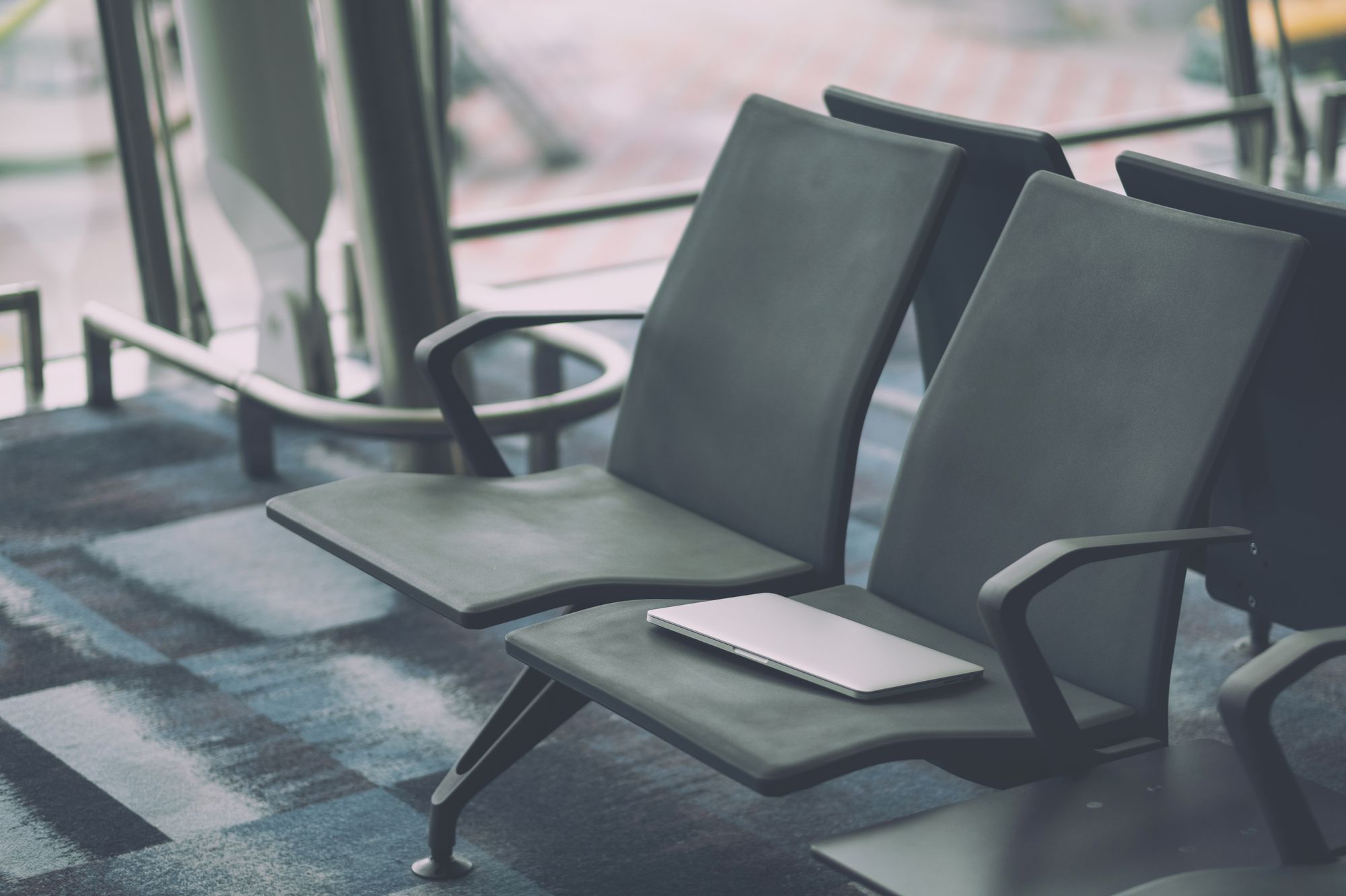 Forgotten laptop on empty chair at airport. 