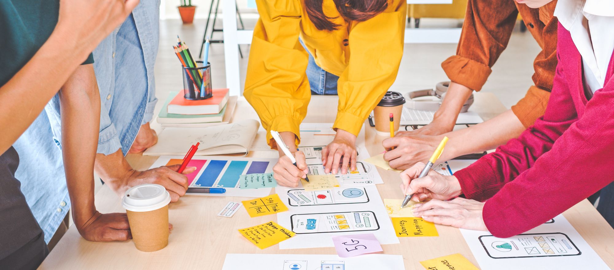 A group of people around a table prototyping on paper.