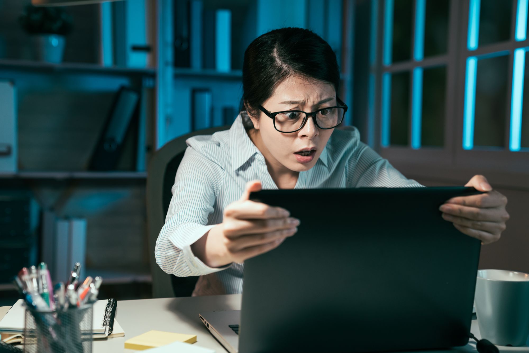 A person that appears shocked while looking at a computer screen.