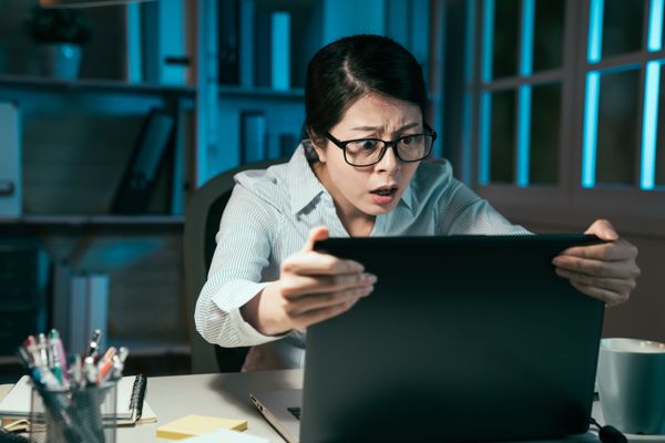 A person that appears shocked while looking at a computer screen.